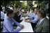 President George W. Bush shares a conversation with Chancellor Angela Merkel of Germany as he and Mrs. Laura Bush enjoy a barbeque dinner in Trinwillershagen as guests of the Chancellor.