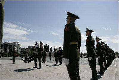 President George W. Bush and Laura Bush follow a Russian honor guard to place a wreath at the Monument to the Heroic Defenders of Leningrad, Friday, July 14, 2006, in St. Petersburg, Russia.