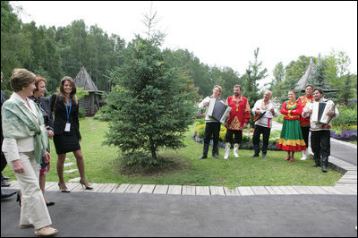 Mrs. Laura Bush and Mrs. Lyudmila Putina are greeted by a traditional Russian Folk group as they arrive at the Podvoriye Restaurant Saturday, July 15, 2006, in St. Petersburg, Russia.