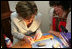 Mrs. Laura Bush receives instruction in arts and crafts Monday, July 17, 2006, during an exhibit at the Baltic Star Hotel on the grounds of the Konstantinovsky Palace Complex in Strelna, Russia, site of the G8 Summit that ended Monday.