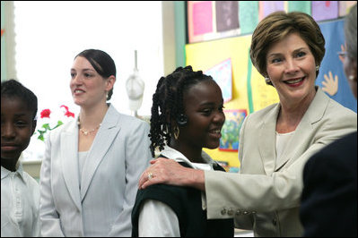 Mrs. Laura Bush congratulates Our Lady of Perpetual Help School student Rajanique White, 10, Monday, June 5, 2006, for the story Rajanique wrote and recited about a small accident that happened to her. Mrs. Bush visited the school to announce a Laura Bush Foundation for America's Libraries grant to Our Lady of Perpetual Help.