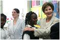 Mrs. Laura Bush congratulates Our Lady of Perpetual Help School student Rajanique White, 10, Monday, June 5, 2006, for the story Rajanique wrote and recited about a small accident that happened to her. Mrs. Bush visited the school to announce a Laura Bush Foundation for America's Libraries grant to Our Lady of Perpetual Help.