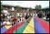 Mrs. Laura Bush joins the children and staff of the Meadowbrook Collaborative Community Center in playing with a colorful parachute during her visit to the facility Tuesday, June 6, 2006 in St. Louis Park, Minn.