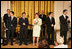 Mrs. Laura Bush stands with members of the cast from the Tony award-winning musical Jersey Boys perform during a luncheon for Senate Spouses in the East Room Monday, June 12, 2006.