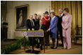 President George W. Bush signs a proclamation to create the Northwestern Hawaiian Islands Marine National Monument at a ceremony Wednesday, June 15, 2006, in the East Room of the White House. The proclamation will bring nearly 140,000 square miles of the Northwestern Hawaiian Island Coral Reef Ecosystem under the nation's highest form of marine environmental protection. Mrs. Laura Bush joined the President and distinguished guests on stage, from left to right, U.S. Rep. Neil Abercrombie, D-Hawaii; U.S. Rep. Ed Case, D-Hawaii; U.S. Sen. Daniel Akaka, D-Hawaii; U.S. Commerce Secretary Carlos Gutierrez; Hawaii Gov. Linda Lingle; documentary filmmaker Jean-Michel Cousteau; marine biologist Sylvia Earle and U.S. Interior Secretary Dirk Kempthorne.