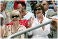 Mrs. Laura Bush and Lynne Pace, wife of General Peter Pace, front-left, applaud the Little League players taking the field at the opening Tee Ball game of the 2006 season on the South Lawn of the White House, Friday, June 23, 2006. General Pace was the Tee Ball Commissioner for the game.