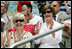 Mrs. Laura Bush and Lynne Pace, wife of General Peter Pace, front-left, applaud the Little League players taking the field at the opening Tee Ball game of the 2006 season on the South Lawn of the White House, Friday, June 23, 2006. General Pace was the Tee Ball Commissioner for the game.