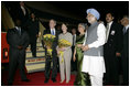 President George W. Bush and Mrs. Bush stand with flowers presented upon their arrival Wednesday, March 1, 2006, at New Delhi's Indira Gandhi International Airport where they were greeted by India's Prime Minister Manmohan Singh, right, and his wife, Gursharan Kaur.