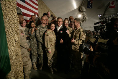 President George W. Bush poses for photos with U.S. and Coalition troops Wednesday, March 1, 2006, during a stopover at Bagram Air Base in Afghanistan, prior to his visit to India and Pakistan.