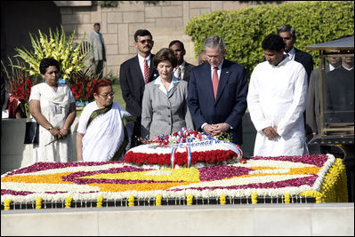 President George W. Bush and Laura Bush are joined by Rajnish Kumar, right, Secretary of the Rajghat Samadhi Committee, and Dr. Nirmila Deshpande, co-Chair of the Rajghat Gandhi Samadhi committee, for a moment of silence at the Mahatma Gandhi Memorial in Rajghat, India on March 2, 2006.