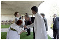 President George W. Bush reaches to shake the hand of Dr. Nirmila Deshpande, as Laura Bush exchanges handshakes with Rajnish Kumar after they were met by the pair Thursday, March 2, 2006 in Rajghat, India for the wreath-laying ceremony at the Mahatma Gandhi Memorial.