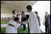 President George W. Bush reaches to shake the hand of Dr. Nirmila Deshpande, as Laura Bush exchanges handshakes with Rajnish Kumar after they were met by the pair Thursday, March 2, 2006 in Rajghat, India for the wreath-laying ceremony at the Mahatma Gandhi Memorial.