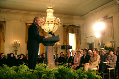 President George W. Bush joins in the celebration of International Women's Day at the White House Tuesday, March 7, 2006, as he thanks the female members of his audience for their leadership. "The struggle for women's right is a story of strong women willing to take the lead," the President told them and added, America's "a better place because of the leadership of women throughout our history."