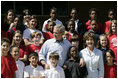 President George W. Bush and Laura Bush pose with students at the College Park Elementary School in Gautier, Miss., Wednesday, March 8, 2006, where Mrs. Bush announced the establishment of The Gulf Coast School Library Recovery Initiative, to help Gulf Coast schools that were damaged by the hurricanes rebuild their book and material collections. The initiative was established by the Laura Bush Foundation for American Libraries.