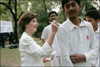 Mrs. Laura Bush signs the jerseys of students from the Schola Nova school and the Islamabad College for Boys, Saturday, March 4, 2006, who participated in a cricket clinic with President George W. Bush at the Raphel Memorial Gardens on the grounds of the U.S. Embassy in Islamabad, Pakistan.