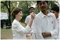 Mrs. Laura Bush signs the jerseys of students from the Schola Nova school and the Islamabad College for Boys, Saturday, March 4, 2006, who participated in a cricket clinic with President George W. Bush at the Raphel Memorial Gardens on the grounds of the U.S. Embassy in Islamabad, Pakistan.