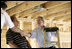 President George W. Bush shakes hands with people helping rebuild Jerry Akins family home, Wednesday, March 8, 2006 in Gautier, Miss., on the site where the Akins home was destroyed by Hurricane Katrina.