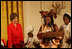 Mrs. Laura Bush reacts to remarks from Aunt Manyongo "Kunene" Mosima Tantoh, a member of the Mothers to Mothers-To-Be organization of South Africa, Monday, March 13, 2006 in the East Room at the White House. Mrs. Bush had earlier met with members of the group, who mentor and counsel mothers who come for prenatal care to clinics and find they are HIV-positive, on her visit to South Africa in July of 2005. Group member Gloria Ncanywa is seen at right.