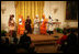 Mrs. Laura Bush listens to a performance from members of the Mothers to Mothers-To-Be representatives of South Africa, Monday, March 13, 2006 in the East Room of the White House. Mrs. Bush had earlier met with the members of the program, who mentor and counsel mothers who come for prenatal care to clinics and find they are HIV-positive, on her visit to South Africa in July of 2005. From left to right on stage are Aunt Manyongo "Kunene" Mosima Tantoh, Nosisi Mngceke, Patty Thomas, Gloria Ncanywa, Monica Abdullah and Babalwa Mbono.