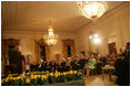 President George W. Bush and Mrs. Laura Bush join their invited guests in listening to Benjamin Franklin interpreter, Ralph Archbold of Philadelphia, Pa., Thursday evening, March 23, 2006 in the East Room of the White House, during a Social Dinner to honor the 300th birthday of Benjamin Franklin.