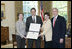 President George W. Bush and Mrs. Bush present the Preserve America award for private preservation to Judy Christa-Cathey, Vice President Brand Management, and Scott Douglas Schrank, Vice President Brand Performance and Support, both of Hampton Hotels' nationwide Save-A-Landmark program, in the Oval Office Monday, May 1, 2006.