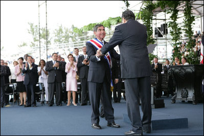 President Oscar Arias is embraced by outgoing President Abel Pacheco during the inaugural at the Estadio Nacional in San Jose, Costa Rica, Monday, May 8, 2006.