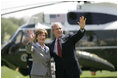 President George W. Bush and Mrs. Laura Bush wave to guests on the South Lawn Friday, May 12, 2006, before boarding Marine One en route Camp David.