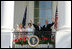 President George W. Bush, Prime Minister John Howard, Mrs. Laura Bush and Mrs. Janette Howard wave from the South Portico of the White House during the State Arrival Ceremony on the South Lawn Tuesday, May 16, 2006.