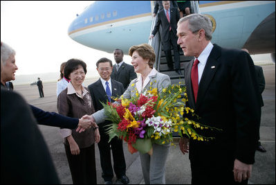 President George W. Bush looks on as Laura Bush is greeted by Patricia L. Herbold, U.S. Ambassador to Singapore, upon their arrival at Paya Lebar Airport Thursday, Nov. 16, 2006, for a two-day visit.