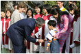 President George W. Bush and Mrs. Laura Bush pause to greet a young boy as they leave church services Sunday, Nov. 19, 2006, at the Cua Bac Church in Hanoi.