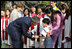 President George W. Bush and Mrs. Laura Bush pause to greet a young boy as they leave church services Sunday, Nov. 19, 2006, at the Cua Bac Church in Hanoi.