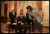 Mrs. Laura Bush, along with family of Ambassador Mark Dybul, watch as U.S. Secretary of State Condoleezza Rice assists newly sworn-in Ambassador Mark Dybul as he signs appointment documents Tuesday, October 10, 2006, during the swearing-in ceremony of Ambassador Mark Dybul in the Benjamin Franklin Room at the US Department of State in Washington, D.C.