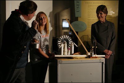 Mrs. Laura Bush watches as David Temple, actor portraying Benjamin Franklin, performs a demonstration related to static electricity at the Houston Museum of Natural Science, Wednesday, October 18, 2006, with the help of a 6th grade student from the Baines Middle School in Houston, TX.