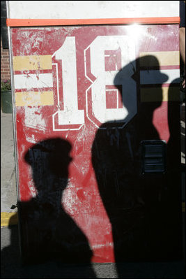 Shadows from New York City First Responders are cast upon a door of Ladder 18, one of the fire trucks destroyed in the September 11th terrorist attacks, during a moment of silence at the Fort Pitt Firehouse in New York City Monday, September 11, 2006.