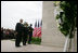 President George W. Bush and Laura Bush, accompanied by Sgt. Timothy Boyd of the Military District of Washington, stand before a memorial wreath Monday, Sept. 11, 2006, during a moment of silence at the Pentagon in Arlington, Va., to commemorate the fifth anniversary of Sept. 11, 2001 attacks.