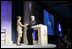 Mrs. Laura Bush is welcomed to the podium by former President Bill Clinton Wednesday, September 20, 2006, at President Clinton's Annual Global Initiative Conference in New York. During her remarks, Mrs. Bush announced a $60 million public-private partnership between the U.S. Government and the Case Foundation to provide clean water for up to 10 million people in sub-Sahara Africa by 2010. The partnership will support the provision and installation of PlayPump water systems in approximately 650 schools, health centers and HIV affected communities.