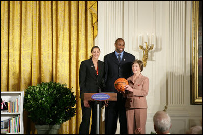 Mrs. Laura Bush stands with Ruth Riley, Detroit Shock WNBA player, left, and Brendan Haywood, Washington Wizards NBA player, after receiving the NBA Cares award Saturday, September, 30, 2006, during the National Book Festival opening ceremony in the East Room of the White House.