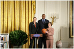 Mrs. Laura Bush stands with Ruth Riley, Detroit Shock WNBA player, left, and Brendan Haywood, Washington Wizards NBA player, after receiving the NBA Cares award Saturday, September, 30, 2006, during the National Book Festival opening ceremony in the East Room of the White House.