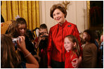 Mrs. Laura Bush poses for a photo with a young guest following the performance of the Ford Theater cast members presentation of "A Christmas Carol," Monday, Dec. 3, 2007, at the White House Children's Holiday Reception. 