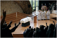 The 'Hooke' em horns' sign is given by mourners at the conclusion of the funeral service for former first lady Lady Bird Johnson Saturday, July 14, 2007, at the Riverbend Center in Austin, Texas.