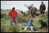 Mrs. Laura Bush works with wildlife biologist John Klavitter to restore native bunchgrass during a tour of Eastern Island on Midway Atoll Thursday, March 1, 2007. Interior Secretary Dirk Kempthorne is pictured in a red jacket.