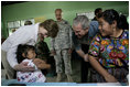 President George W. Bush and Mrs. Laura Bush play with a young girl during a visit Monday, March 12, 2007, to the Carlos Emilio Leonardo School in Santata Cruz Balanya, Guatemala. The couple visited a medical readiness and training exercise site at the school.