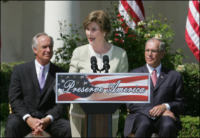 Mrs. Laura Bush is joined by U.S. Secretary of the Interior Dirk Kempthrone, left, and Jon Nau III, chairman of the Advisory Council on Historic Preservation, as she addreses guests in the White House Rose Garden, Wednesday, May 9, 2007, during the Preserve America President Awards ceremony.