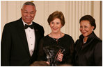 Mrs. Laura Bush is joined on stage by former Secretary of State Colin Powell and his wife, Alma Powell, as they present Mrs. Bush with a National Promise of America Founders Award, Tuesday evening, Nov. 13, 2007, during a social dinner to celebrate the tenth anniversary of America's Promise-The Alliance for Youth.