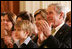 President George W. Bush and Mrs. Laura Bush are joined by Elijah Atkins, Friday, Nov. 16, 2007 in the East Room of the White House, as they listen to Atkins' father, country music star Rodney Atkins, performing for guests during the celebration of National Adoption Day. Rodney Atkins is the 2007-2008 national celebrity spokesperson for The National Council for Adoption.