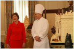 Laura Bush stands with White House Pastry Chef Bill Yosses during the press preview Thursday, Nov. 29, 2007, in the State Dining Room. They discussed the gingerbread White House. Based on a foundation of gingerbread, the structure consists of 300 pounds of white chocolate and gingerbread. 