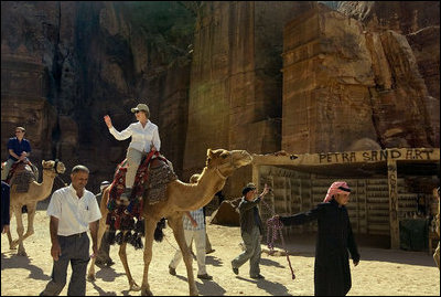 Mrs. Laura Bush takes a ride on a camel while touring Petra, an ancient city in southern Jordan Friday, Oct. 26, 2007. In 1997, a carved relief depicting two pairs of camels and camel drivers were discovered at the entrance of the city. During its time, Petra was a caravan city and trading center for the entire region.