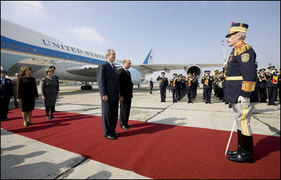 President George W. Bush stands with President Traian Basescu of Romania, during welcoming ceremonies Wednesday, April 2, 2008, at Mihail Kogalniceanu Airport in Constanta, Romania. With them on the red carpet are Mrs. Laura Bush and Mrs. Maria Basescu.