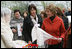 Mrs. Laura Bush spends a moment with a traditional handicraft artisan at the Dimitrie Gusti Village during an outing Thursday, April 3, 2008, with NATO spouses to the Bucharest open-air museum.