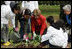 Mrs. Laura Bush helps children plant flowers at the First Bloom Event, Monday, April 21, 2008, during her visit to celebrate National Park week at the Castle Clinton National Monument in New York City.